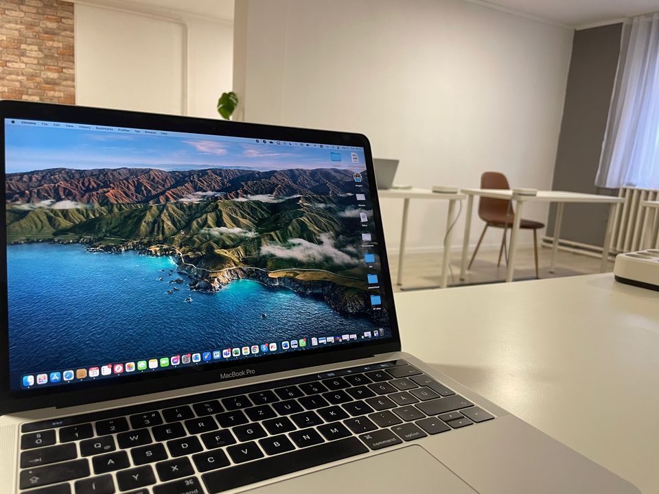 Laptop egy fehér munkaasztalon a GDL Office nagytermében